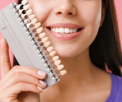 A patient smiling confidently after getting custom dental veneers in Leigh, showcasing a bright, even smile with natural-looking results.